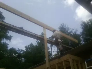 Carpenter setting a ridge beam over a new addition frame — Ice Dam Removal by Roofing Brothers in Hebron
